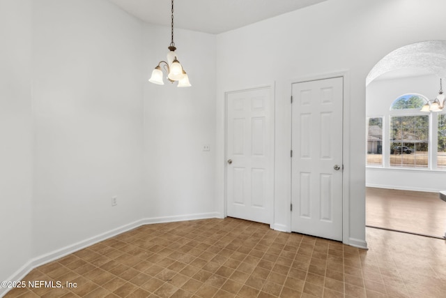 unfurnished room with an inviting chandelier