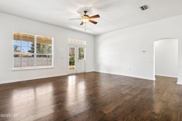 empty room featuring a textured ceiling, dark wood-type flooring, and ceiling fan