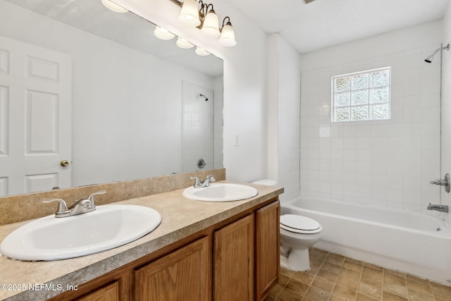 full bathroom with tiled shower / bath combo, vanity, and toilet