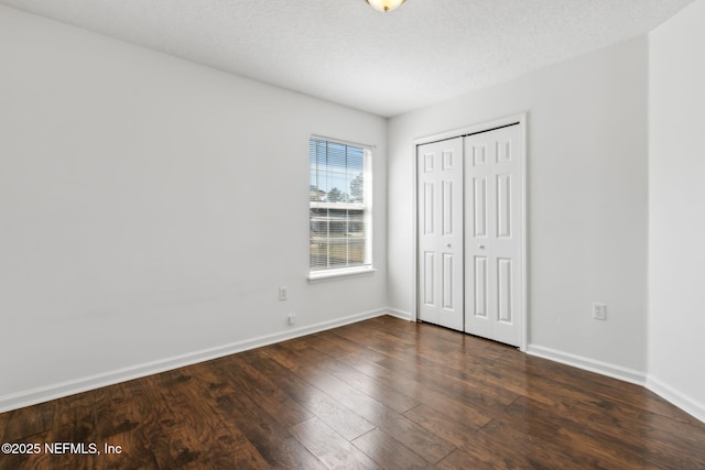 unfurnished bedroom with dark hardwood / wood-style flooring, a closet, and a textured ceiling