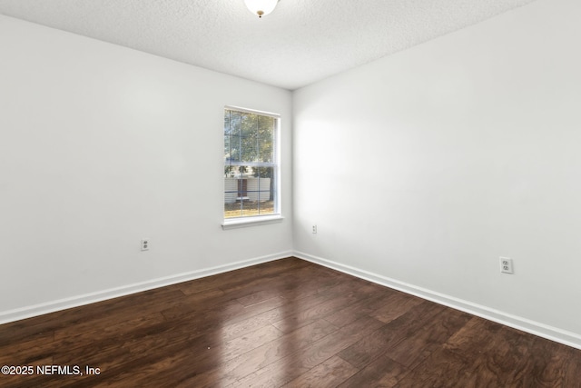 spare room featuring wood-type flooring and a textured ceiling