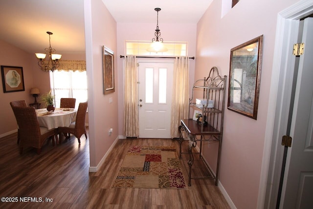 foyer with hardwood / wood-style floors and a notable chandelier