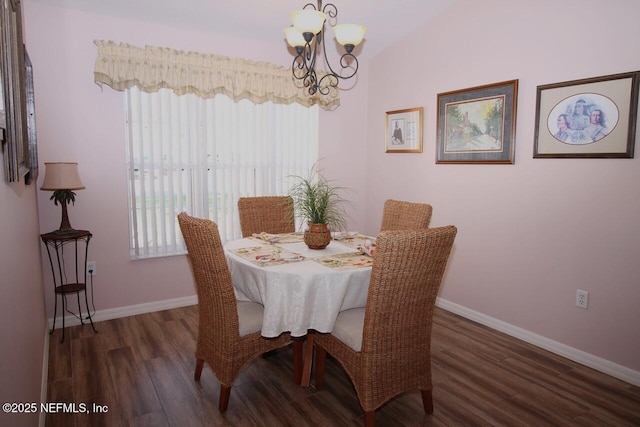 dining space with an inviting chandelier and dark hardwood / wood-style flooring