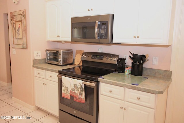 kitchen with white cabinetry, appliances with stainless steel finishes, and light tile patterned floors