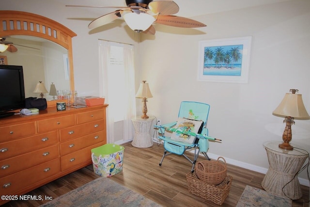 sitting room featuring ceiling fan and dark hardwood / wood-style floors