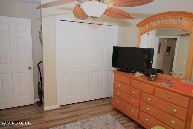 bedroom with light hardwood / wood-style floors, a closet, and ceiling fan