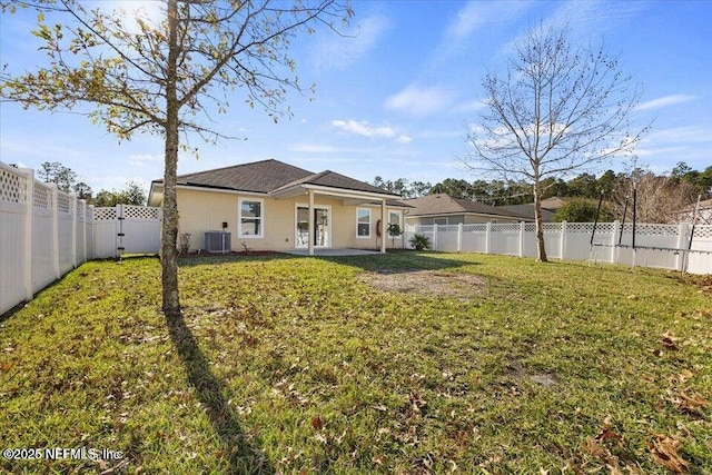 rear view of house featuring a yard and central AC unit