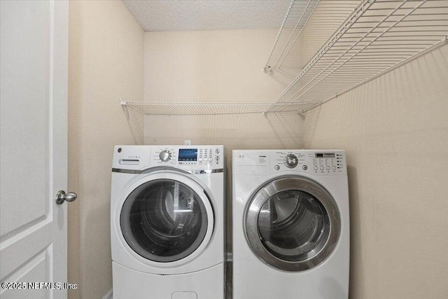 laundry area featuring separate washer and dryer and a textured ceiling