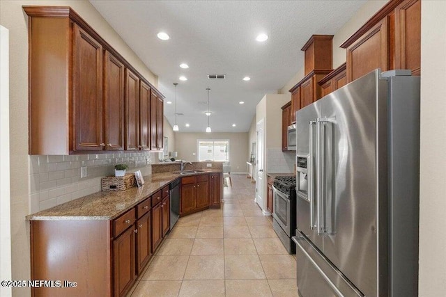 kitchen with sink, light tile patterned floors, appliances with stainless steel finishes, tasteful backsplash, and light stone countertops