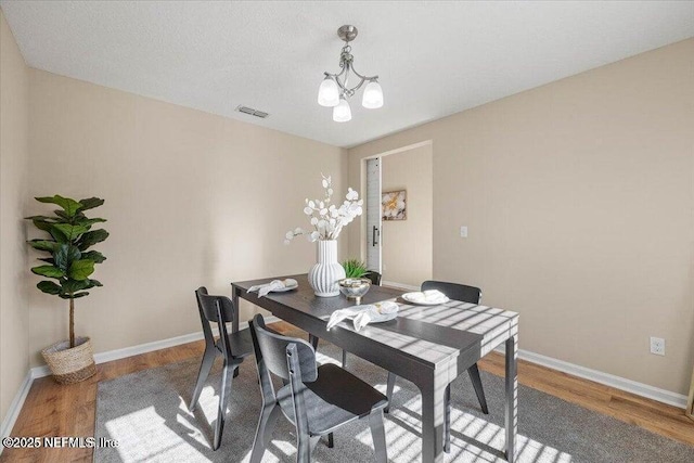 dining room with a notable chandelier and hardwood / wood-style flooring