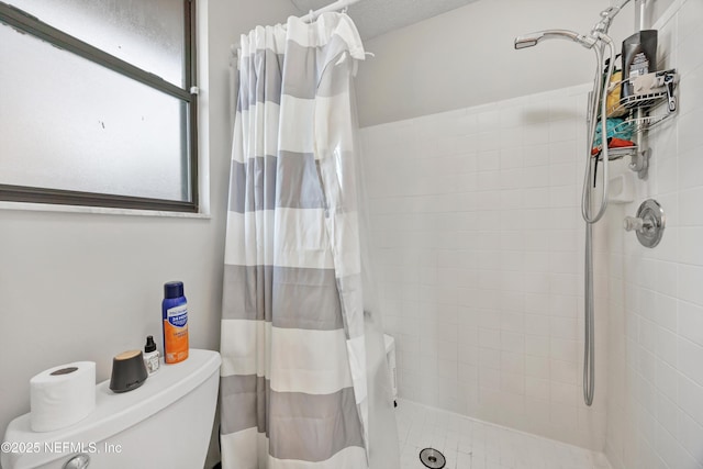 bathroom featuring curtained shower and toilet