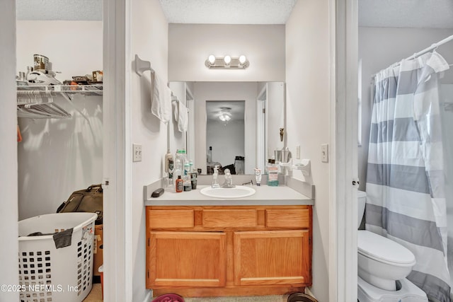 bathroom with vanity, a textured ceiling, a shower with curtain, and toilet