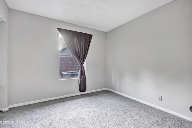 carpeted empty room featuring a textured ceiling