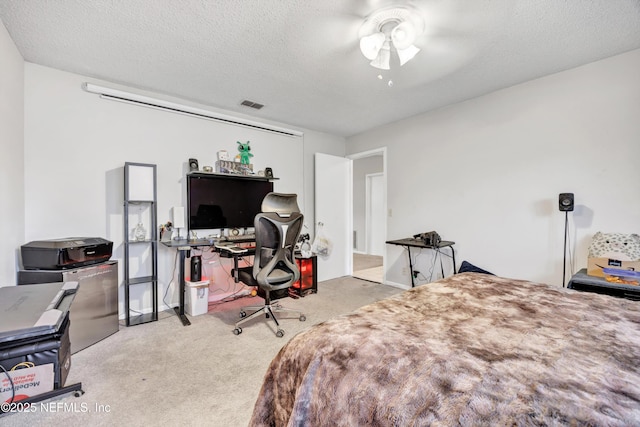 carpeted bedroom with ceiling fan and a textured ceiling