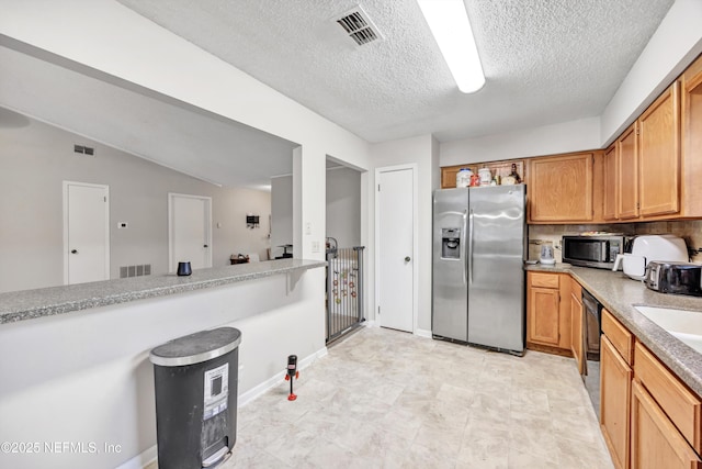 kitchen with tasteful backsplash, appliances with stainless steel finishes, lofted ceiling, and a textured ceiling