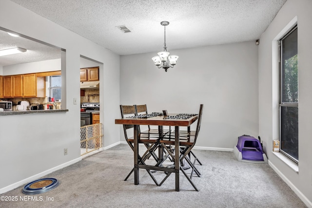 carpeted dining room featuring a textured ceiling and a chandelier