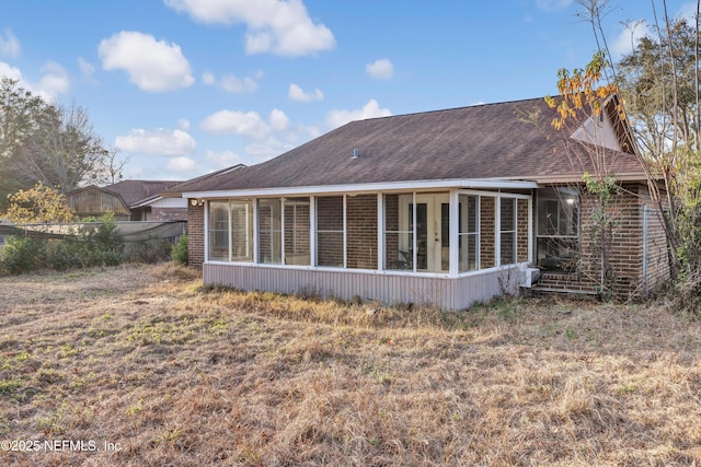 back of property with a sunroom