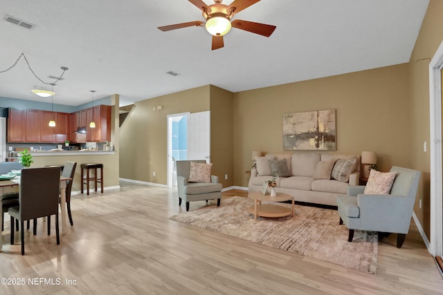 living room featuring ceiling fan and light hardwood / wood-style floors