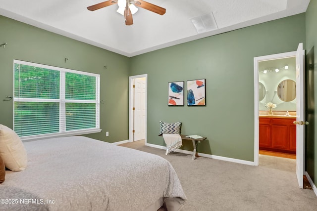 bedroom with light colored carpet, ceiling fan, and ensuite bathroom