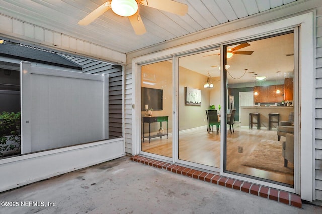 view of exterior entry featuring a patio and ceiling fan