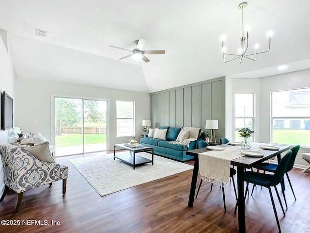 living room with ceiling fan with notable chandelier, lofted ceiling, dark hardwood / wood-style floors, and a wealth of natural light