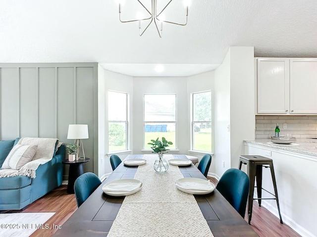 dining room with light hardwood / wood-style flooring and a notable chandelier