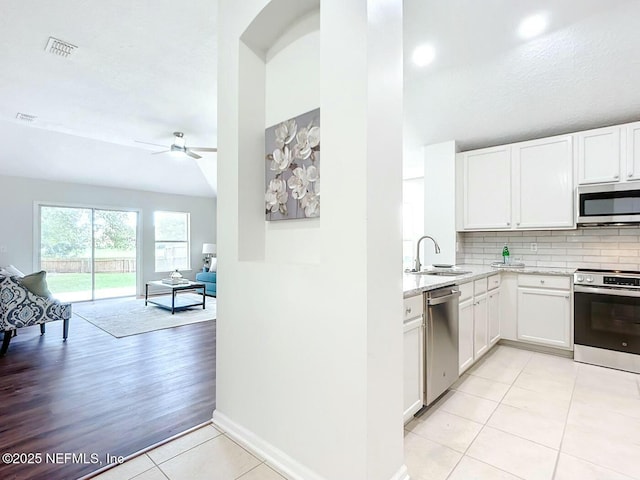 kitchen with white cabinetry, appliances with stainless steel finishes, sink, and decorative backsplash