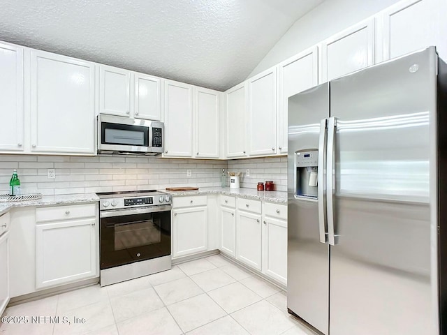 kitchen featuring light stone countertops, appliances with stainless steel finishes, and white cabinets