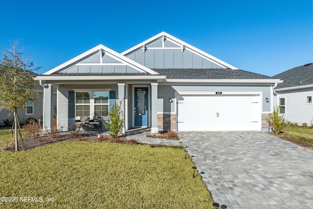 view of front of property featuring a garage, a front yard, and covered porch