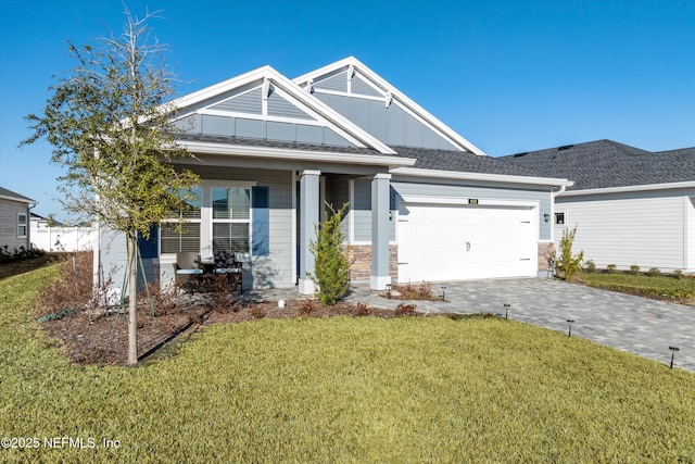 view of front of property with a garage, a front yard, and covered porch