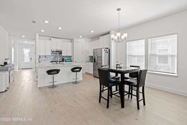 dining space featuring a notable chandelier and light hardwood / wood-style floors