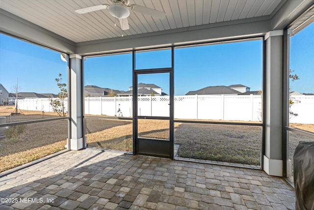 unfurnished sunroom with ceiling fan