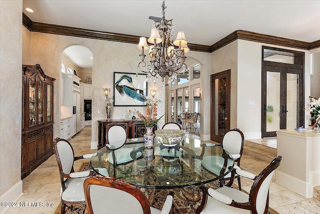 dining space featuring ornamental molding, a chandelier, and french doors