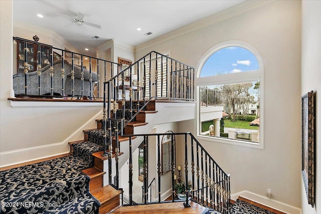 stairs with ceiling fan, ornamental molding, and wood-type flooring