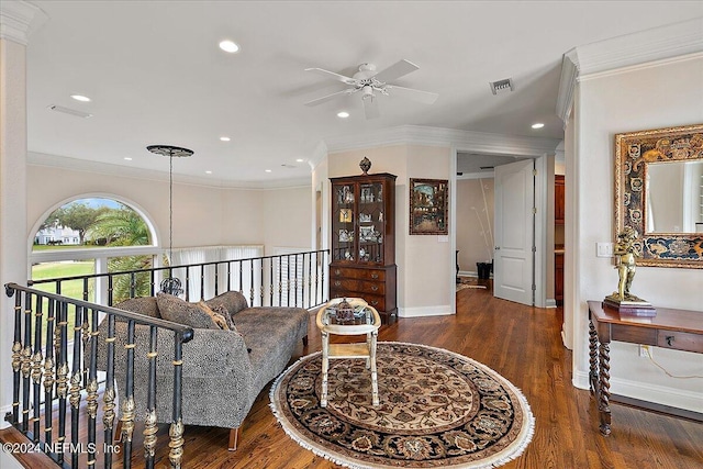 living room with dark wood-type flooring, ceiling fan, and crown molding