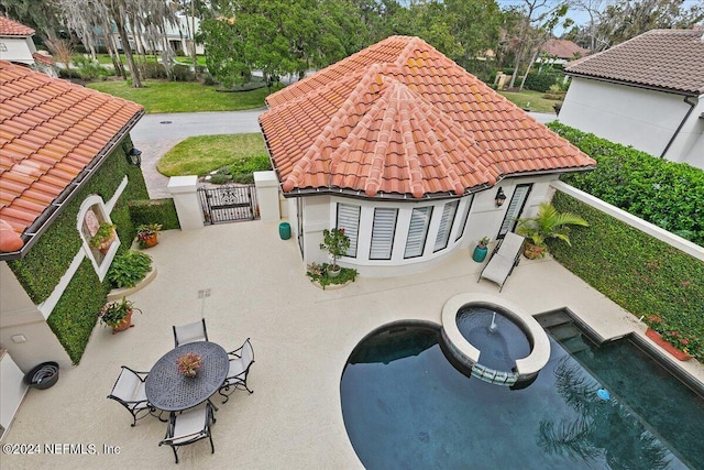 exterior space featuring an in ground hot tub and a patio