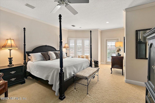 carpeted bedroom with ornamental molding, ceiling fan, and a textured ceiling