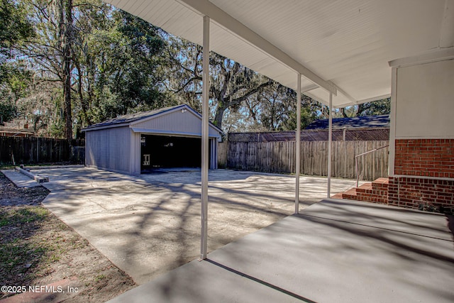 view of patio / terrace featuring a garage and an outbuilding