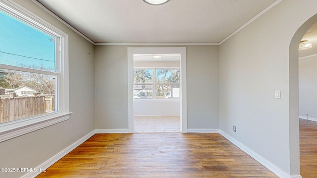 unfurnished room featuring ornamental molding and light hardwood / wood-style floors