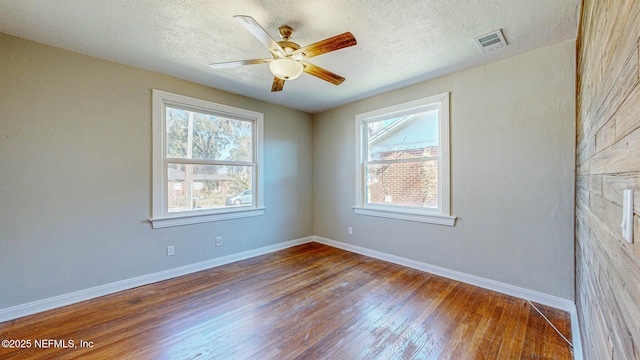 empty room with hardwood / wood-style floors, a textured ceiling, and ceiling fan