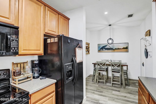 kitchen with decorative light fixtures, light hardwood / wood-style flooring, and black appliances