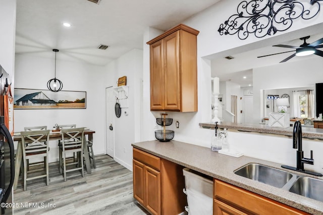 kitchen featuring sink, light hardwood / wood-style flooring, dishwasher, ceiling fan, and decorative light fixtures