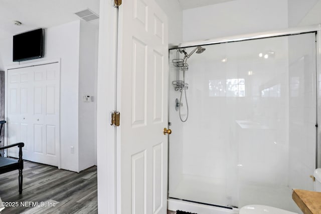 bathroom with a shower with door and hardwood / wood-style flooring