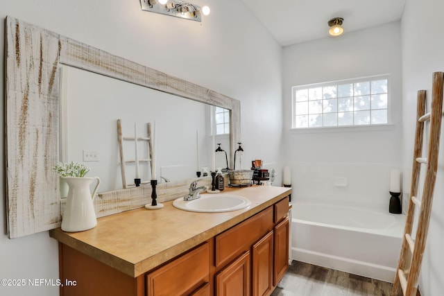 bathroom featuring a tub to relax in, hardwood / wood-style floors, and vanity