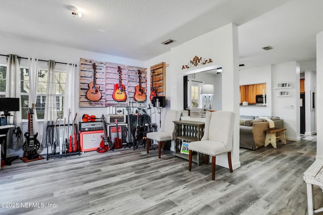 sitting room with hardwood / wood-style floors and a textured ceiling