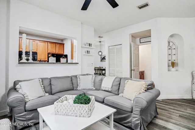 living room with dark wood-type flooring and ceiling fan