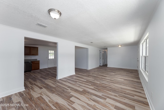 unfurnished living room with light hardwood / wood-style floors and a textured ceiling