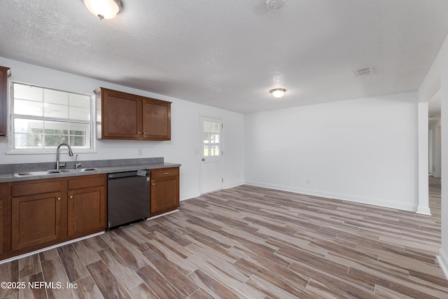 kitchen with plenty of natural light, black dishwasher, sink, and light hardwood / wood-style floors