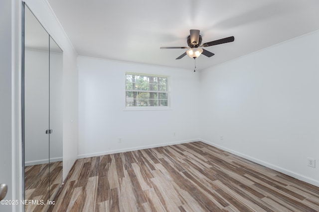 empty room featuring wood-type flooring, ornamental molding, and ceiling fan