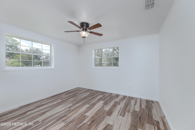 empty room featuring crown molding, ceiling fan, and light wood-type flooring